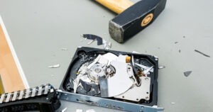 Destroying computer hard drive with a hammer.
